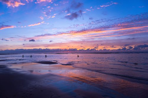 Free Vibrant sunset over Casablanca beach with reflective water and silhouettes. Stock Photo
