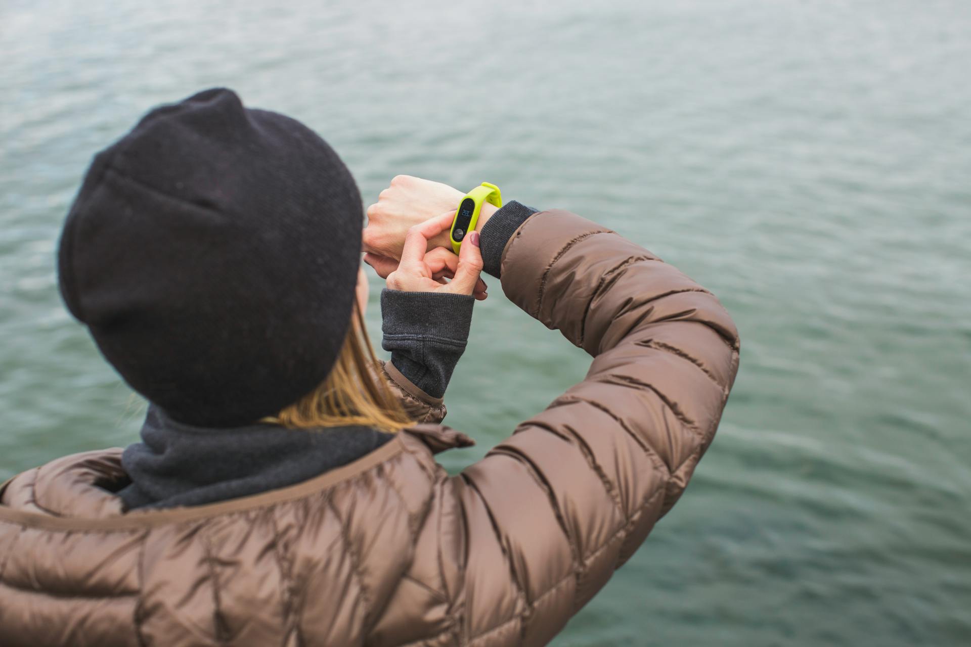 Woman Looking at Black and Yellow Activity Tracker