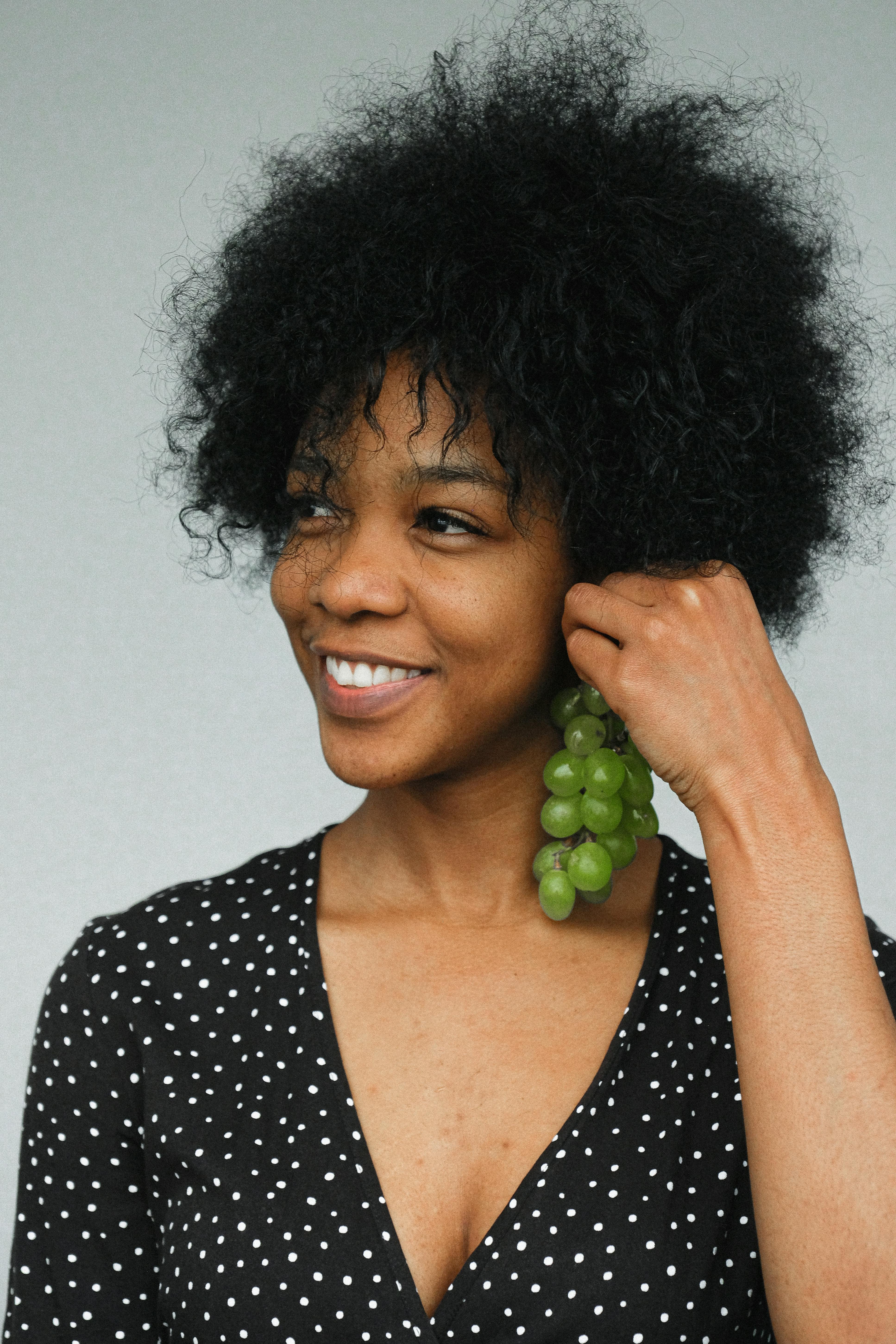 smiling woman with natural grape as earring