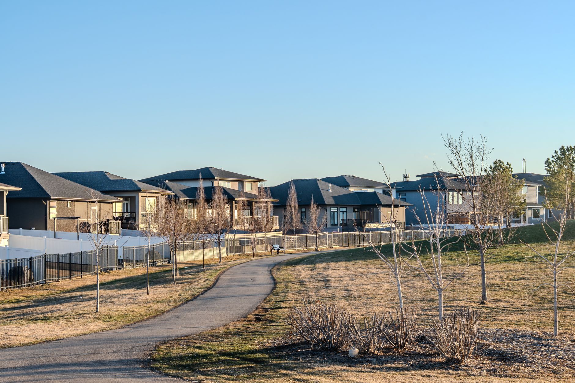 Peaceful suburban neighborhood with houses and pathway, captured during the early spring season.