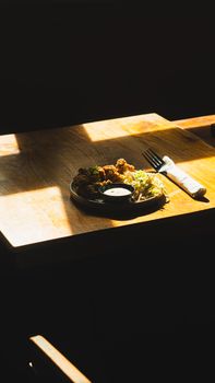 A rustic table with a meal plated in natural light, offering a cozy dining experience.