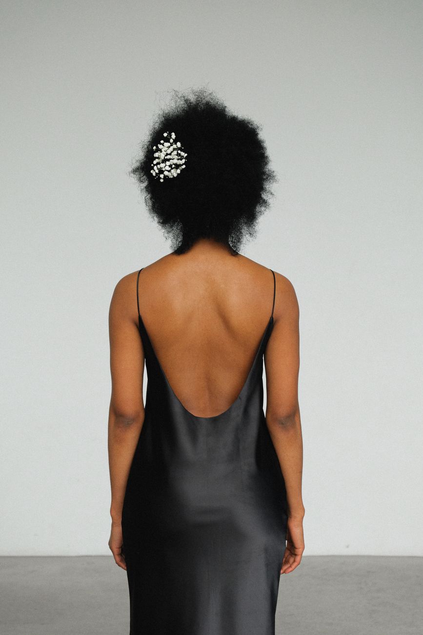Fashionable black woman in a chic evening dress with elegant hairstyle.