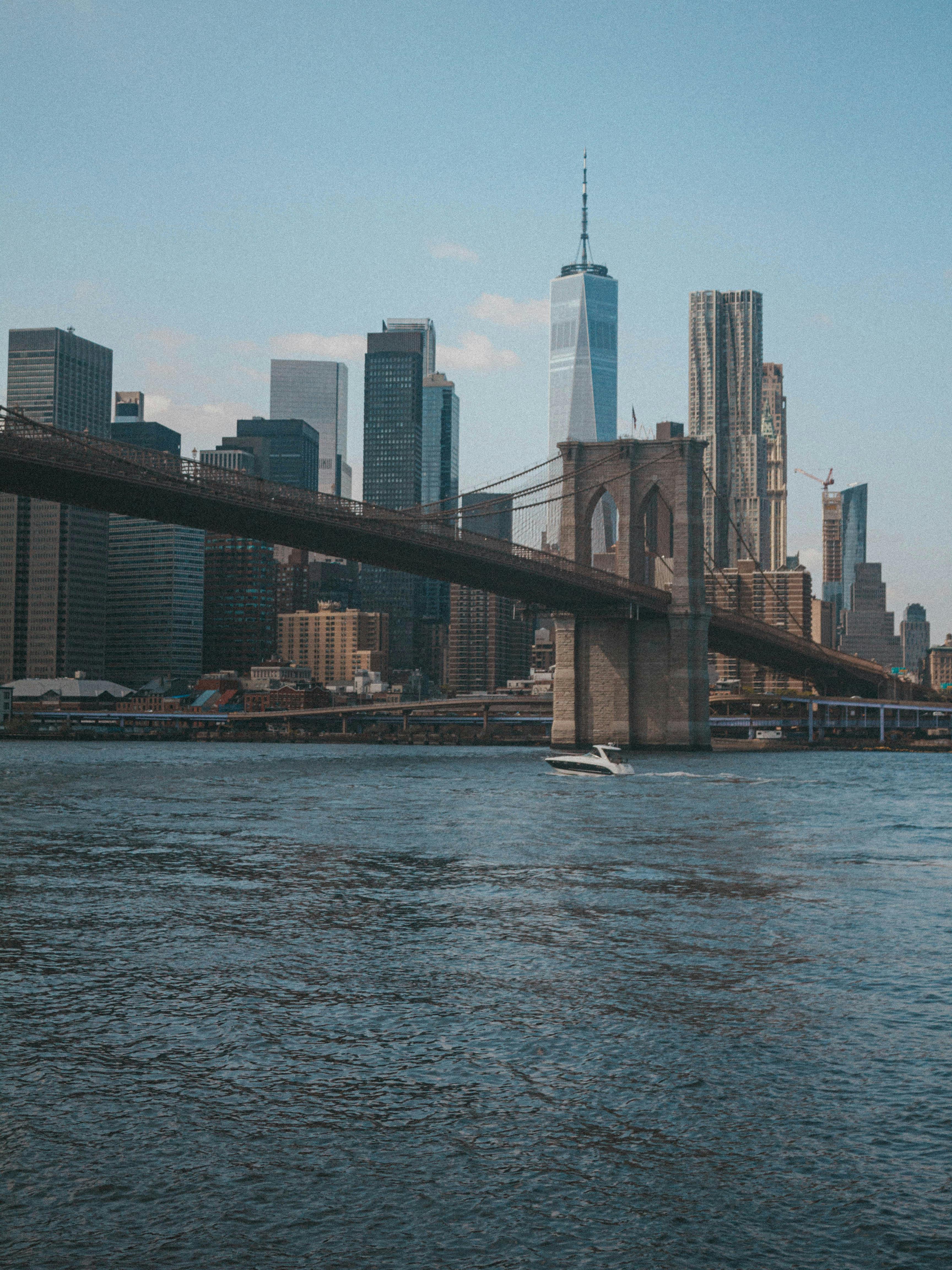 View of Brooklyn Bridge and New York City skyline over the East River on a clear day.