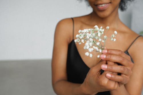 Vrouw In Zwarte Spaghettibovenkant Met Witte Bloem In Haar Hand