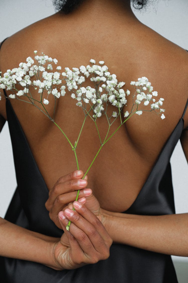 Close-up Photo Of Woman In Black Night Dress Holding White Flower Behind Her Back