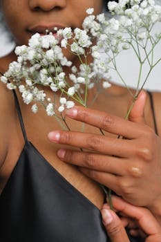 手持白花的女子特写，展现自然之美