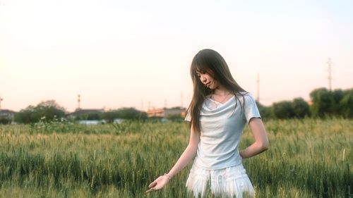 Free A serene scene of a young woman in a wheat field during sunset, capturing tranquility. Stock Photo