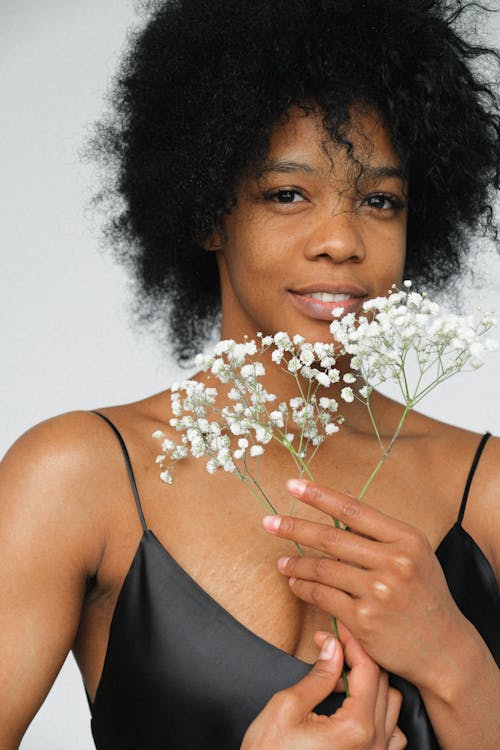 Woman in Black Spaghetti Strap Top With White Flowers