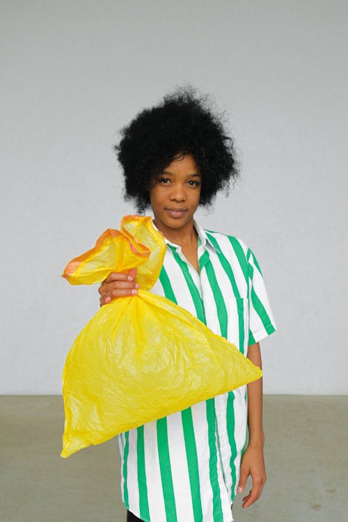 Woman Holding Yellow Plastic Bag