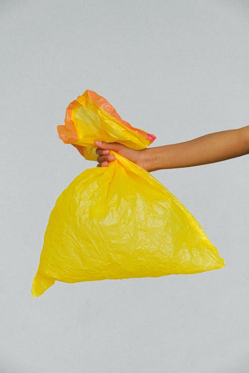 Mãos Segurando Um Saco Plástico Amarelo