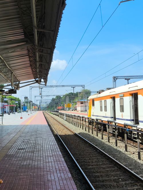 Free A detailed view of a modern train station platform with a train and clear blue sky. Stock Photo