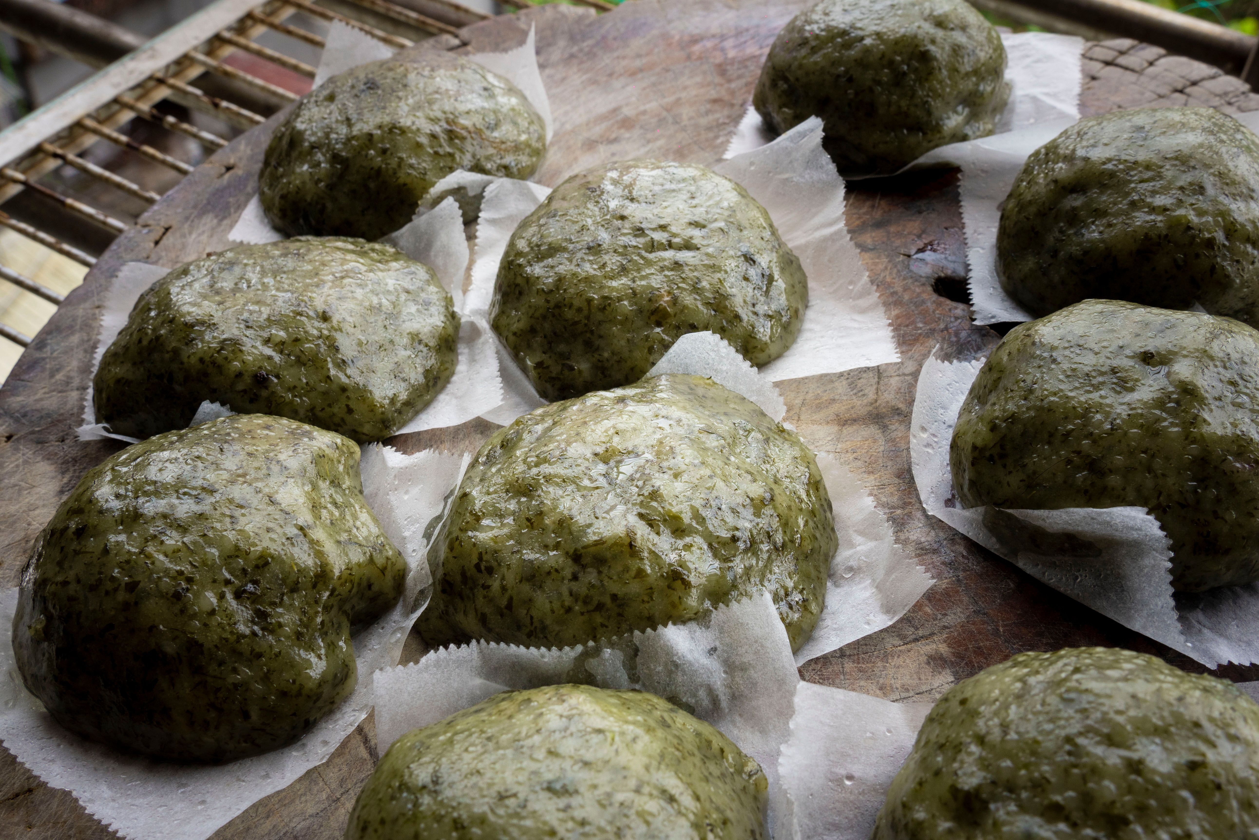 Delicious traditional Taiwanese grass rice cakes freshly prepared and displayed on a wooden board.