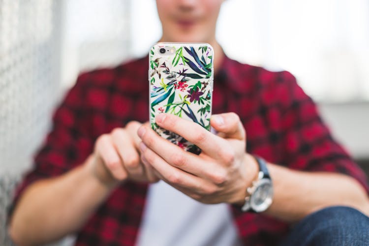Person Holding Multicolored Floral Iphone Case