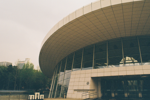 Free A futuristic building with a circular roof and glass facade, showcasing modern architecture. Stock Photo
