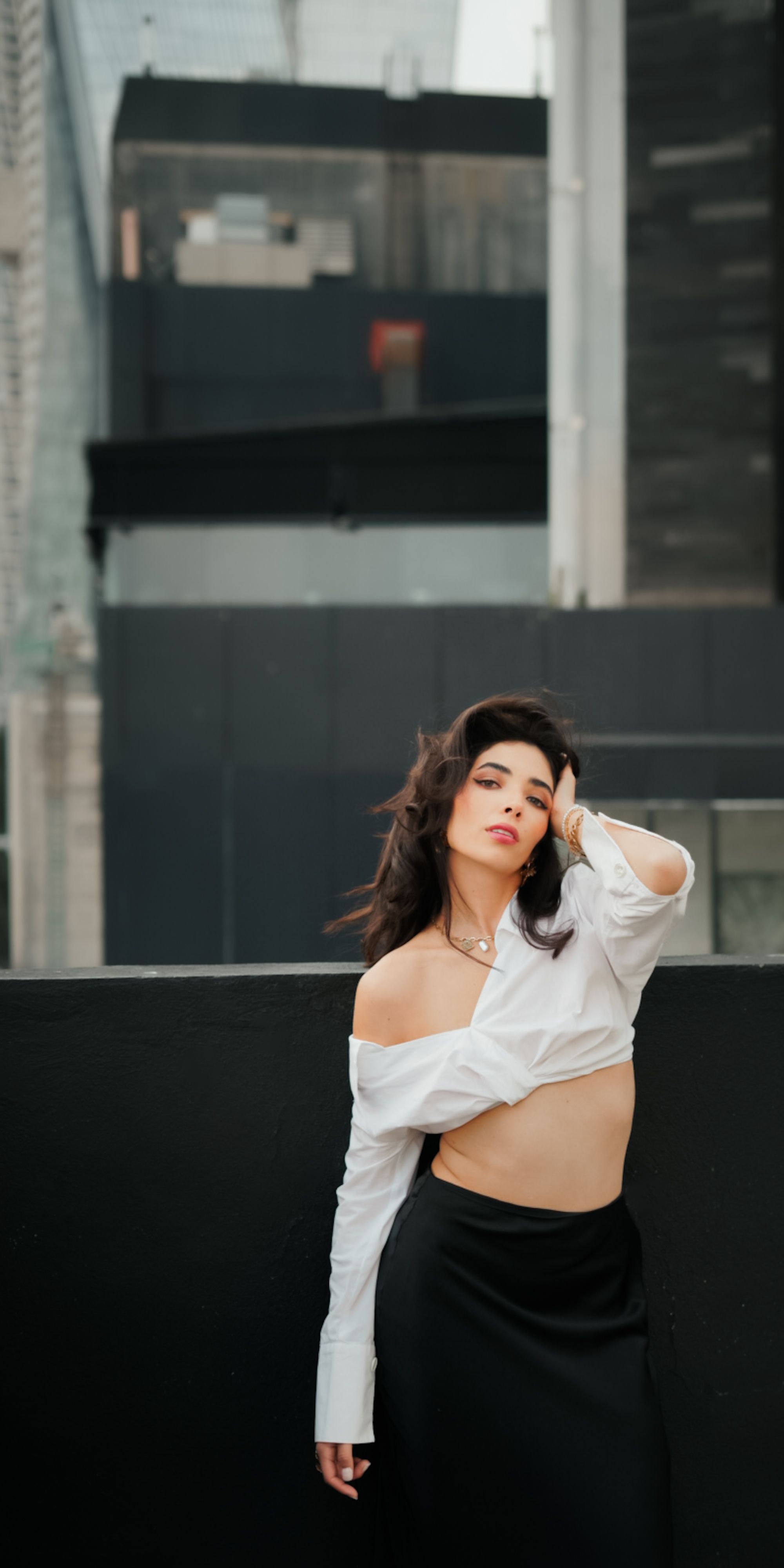 Stylish model poses on a city rooftop, capturing urban elegance and modern fashion vibes.