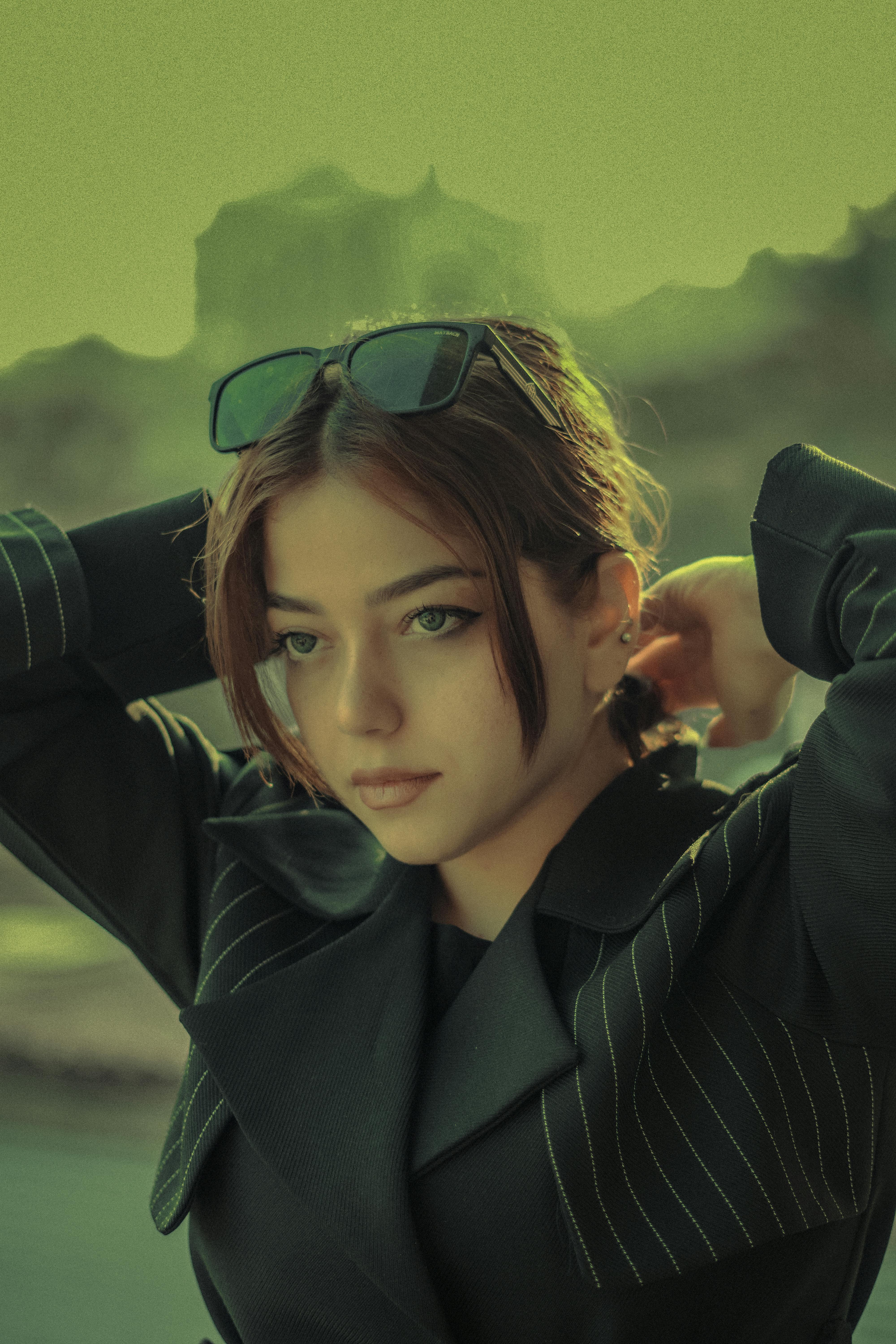 Elegant portrait of a young woman in a chic outfit with moody lighting.