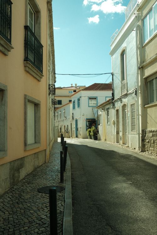 Free Picturesque narrow street with charming European architecture under a bright blue sky. Stock Photo
