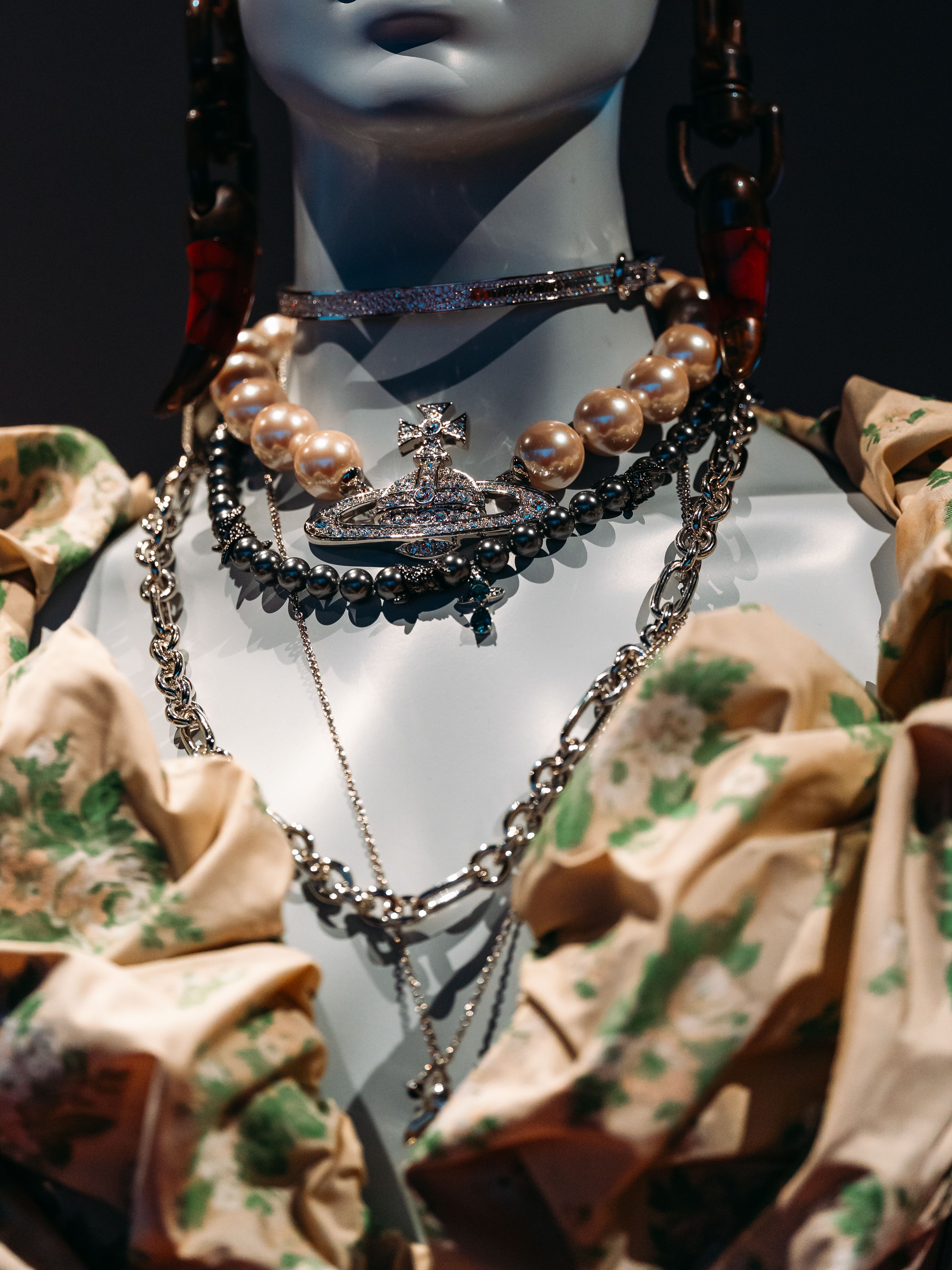 Superposition de plusieurs colliers dorés sur un mannequin