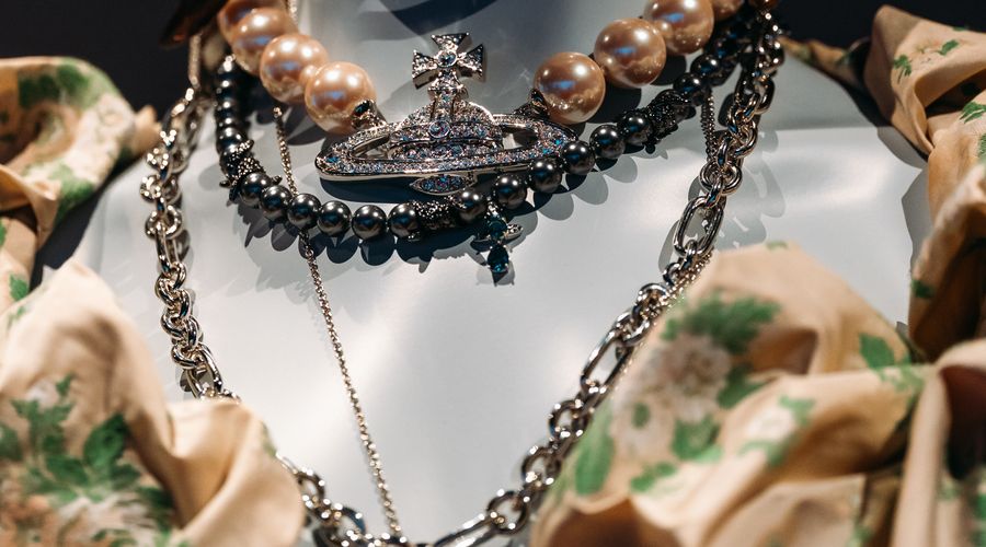 Superposition de plusieurs colliers dorés sur un mannequin