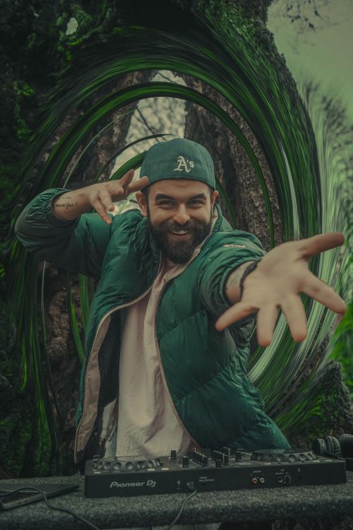 Free Dynamic DJ performing with energy in an outdoor setting. Stock Photo