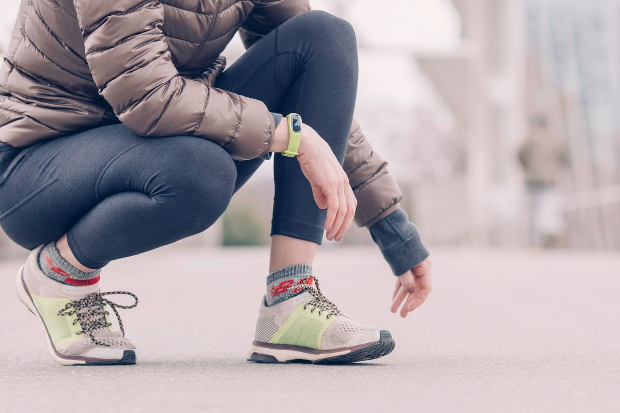 Close-up of a runner crouching, showing running shoes, socks and leggings