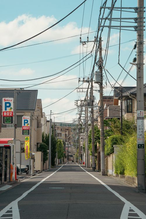 Free Straight view down a suburban Tokyo street lined with power lines and buildings. Stock Photo