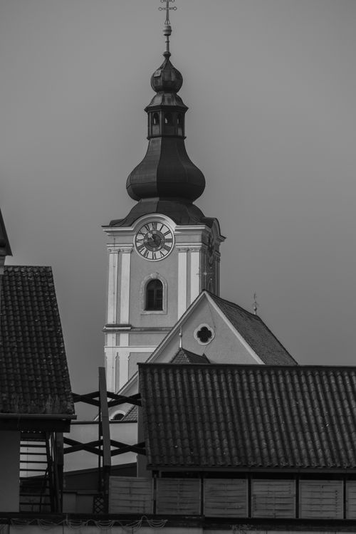 Free Black and white photo of a historic church steeple amid rooftops in Mürzzuschlag, Austria. Stock Photo