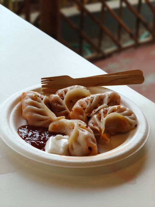 Free Plate of dumplings served with sauces and wooden cutlery in Bengaluru. Stock Photo