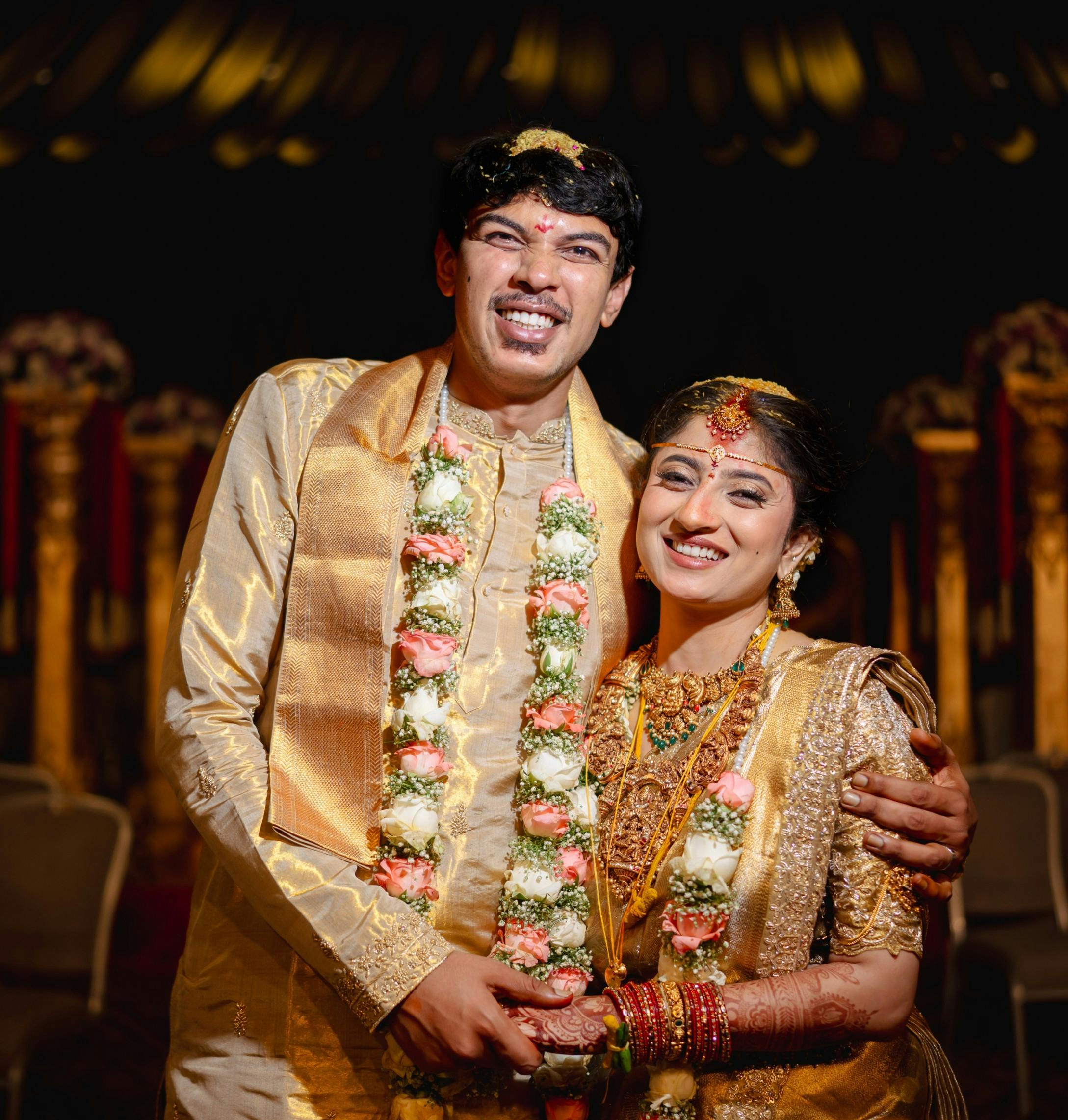 A joyful Indian couple in traditional wedding attire celebrating their special day.