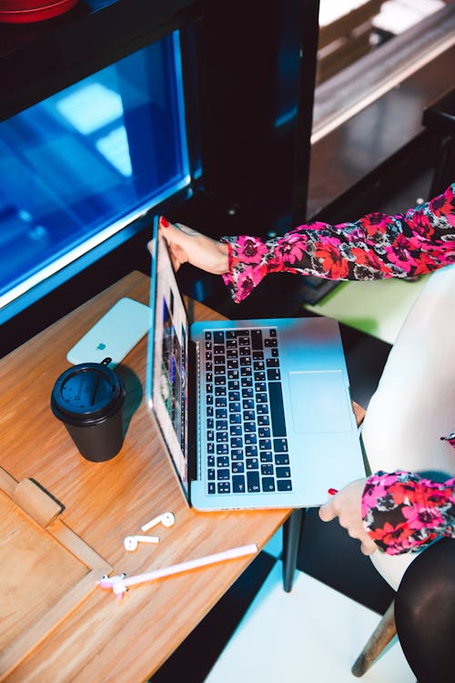 Frau Im Roten Und Schwarzen Blumenkleid Mit Macbook Pro