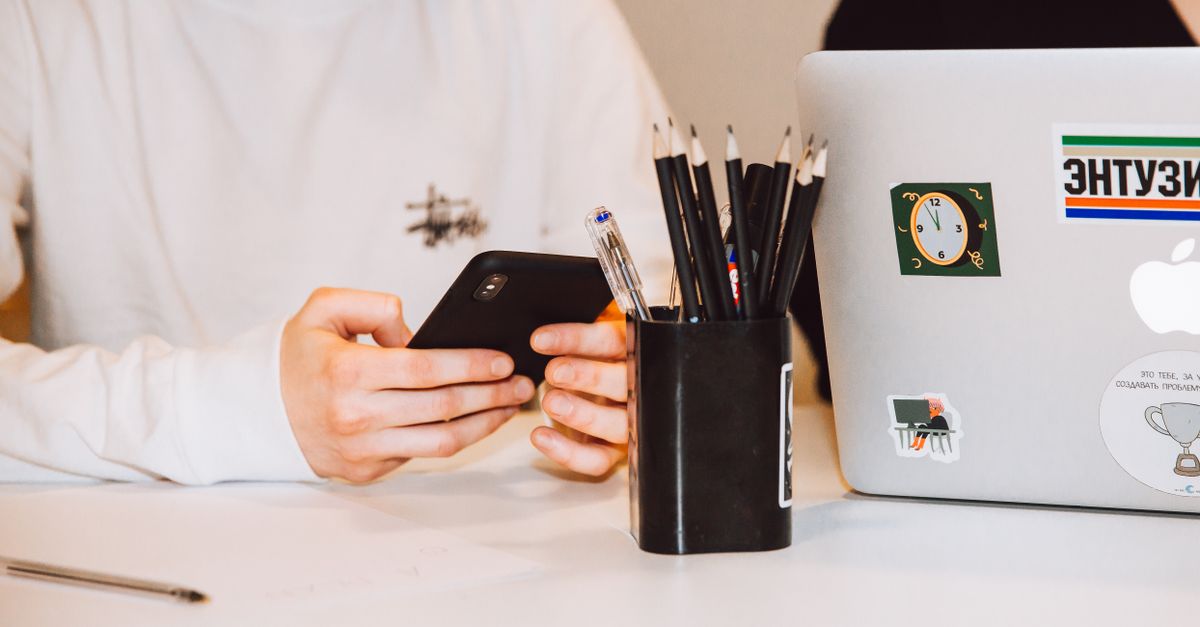 person texting on phone at desk