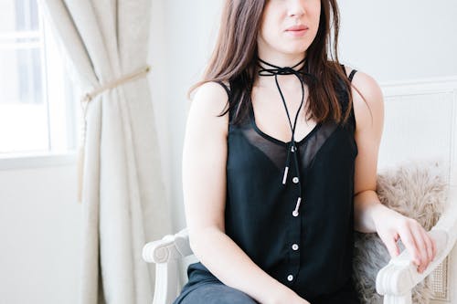 Woman Sitting on White Armchair