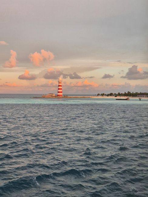 A beautiful view of the Bimini lighthouse during sunset over calm ocean waters, creating a serene landscape.