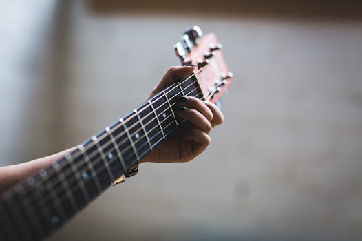 A detailed view of a person's hand strumming an acoustic guitar. Musical creativity.