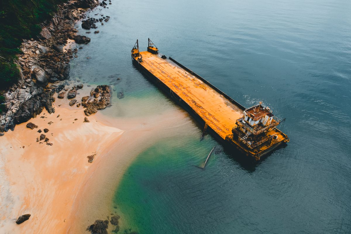 Large cargo ship beached on shore, representing the ship-breaking industry near Bhavnagar's Alang yard