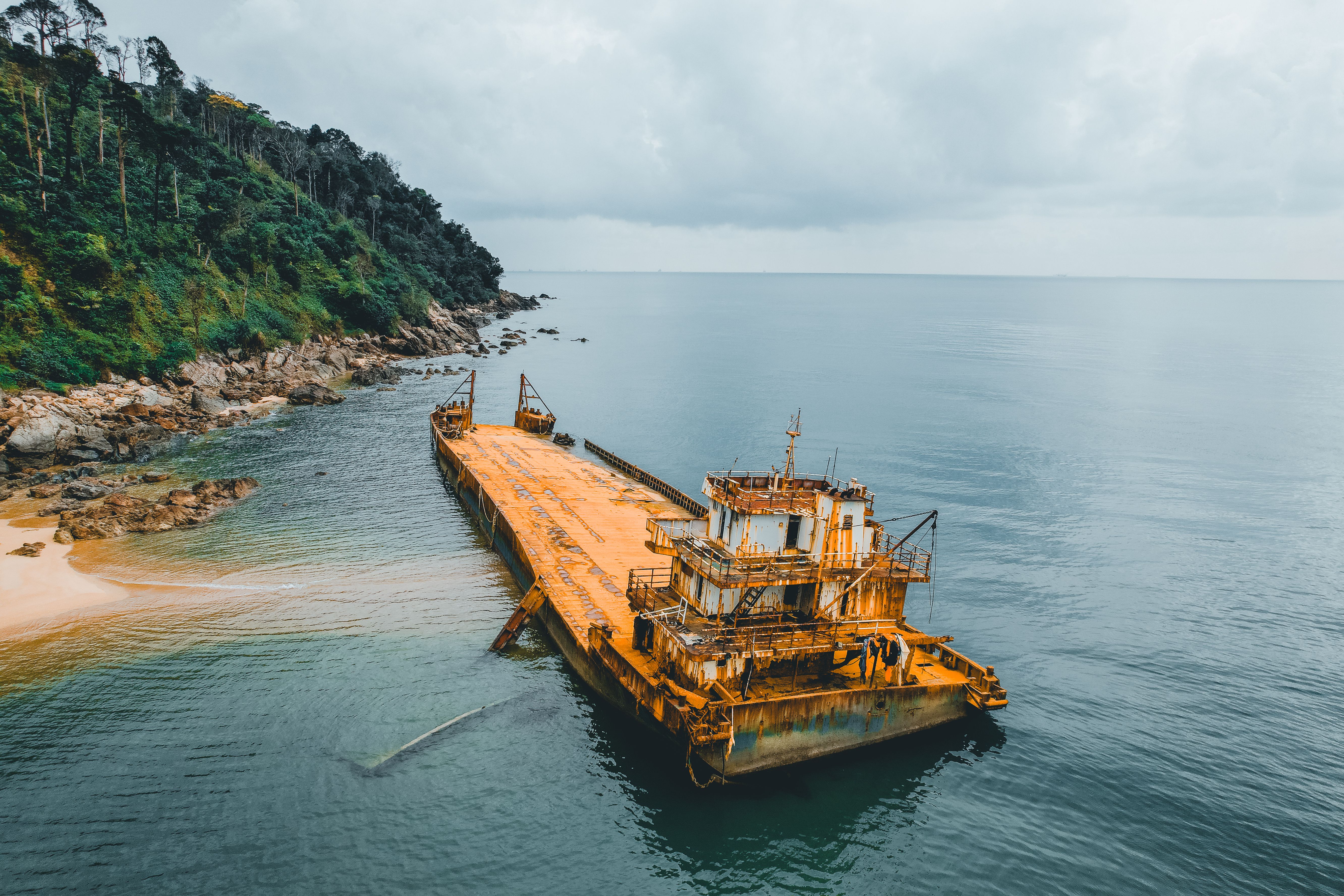 Rusty Shipwreck Near Pristine Jungle Coastline · Free Stock Photo