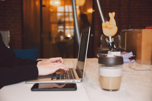 Free Person Using Macbook Pro on White Table Stock Photo