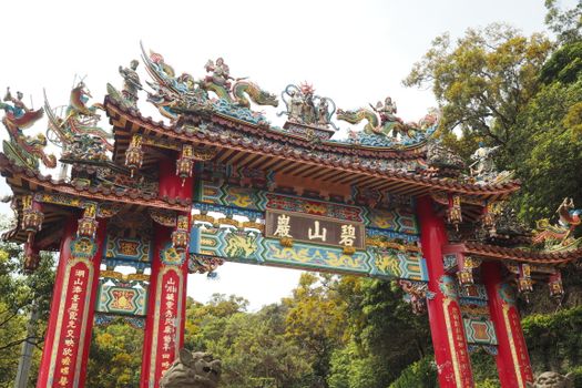 Vibrant and ornate Chinese temple gate with intricate dragon sculptures.