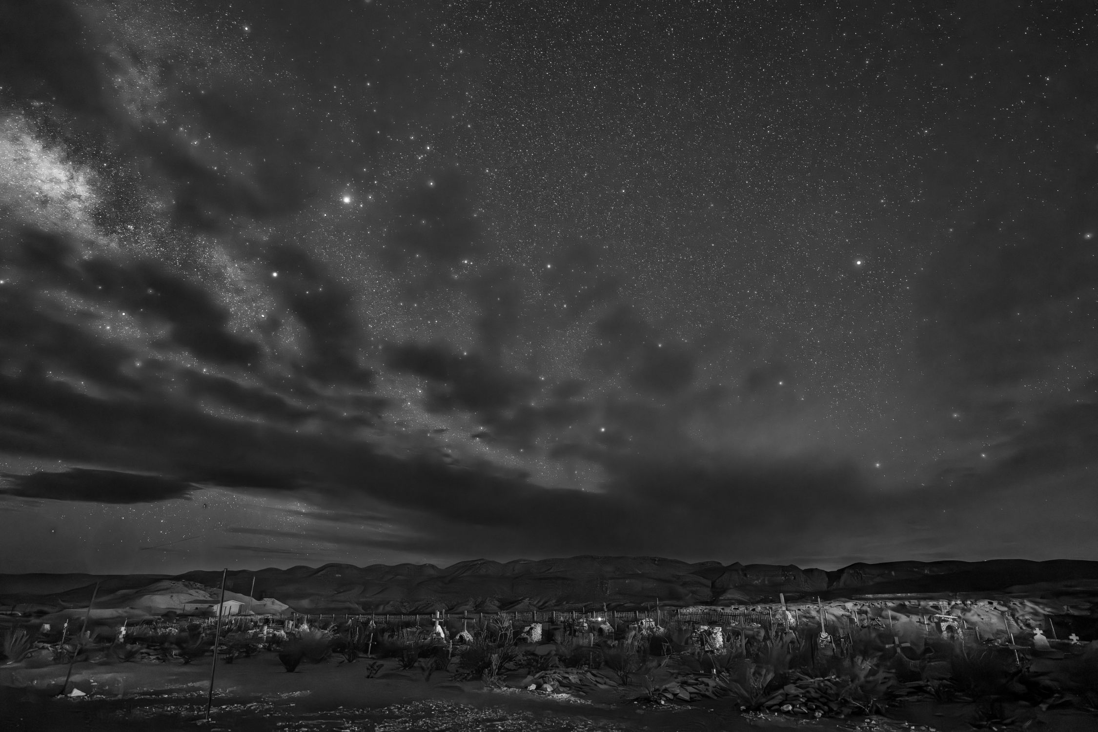 A stunning black and white capture of a starry night sky over the desert landscape of Terlingua, Texas.
