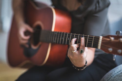 Woman Playing Brown Acoustic Guitar