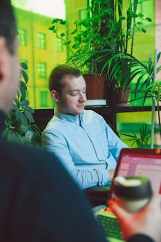 Young professionals in a vibrant office setting with lush green plants.
