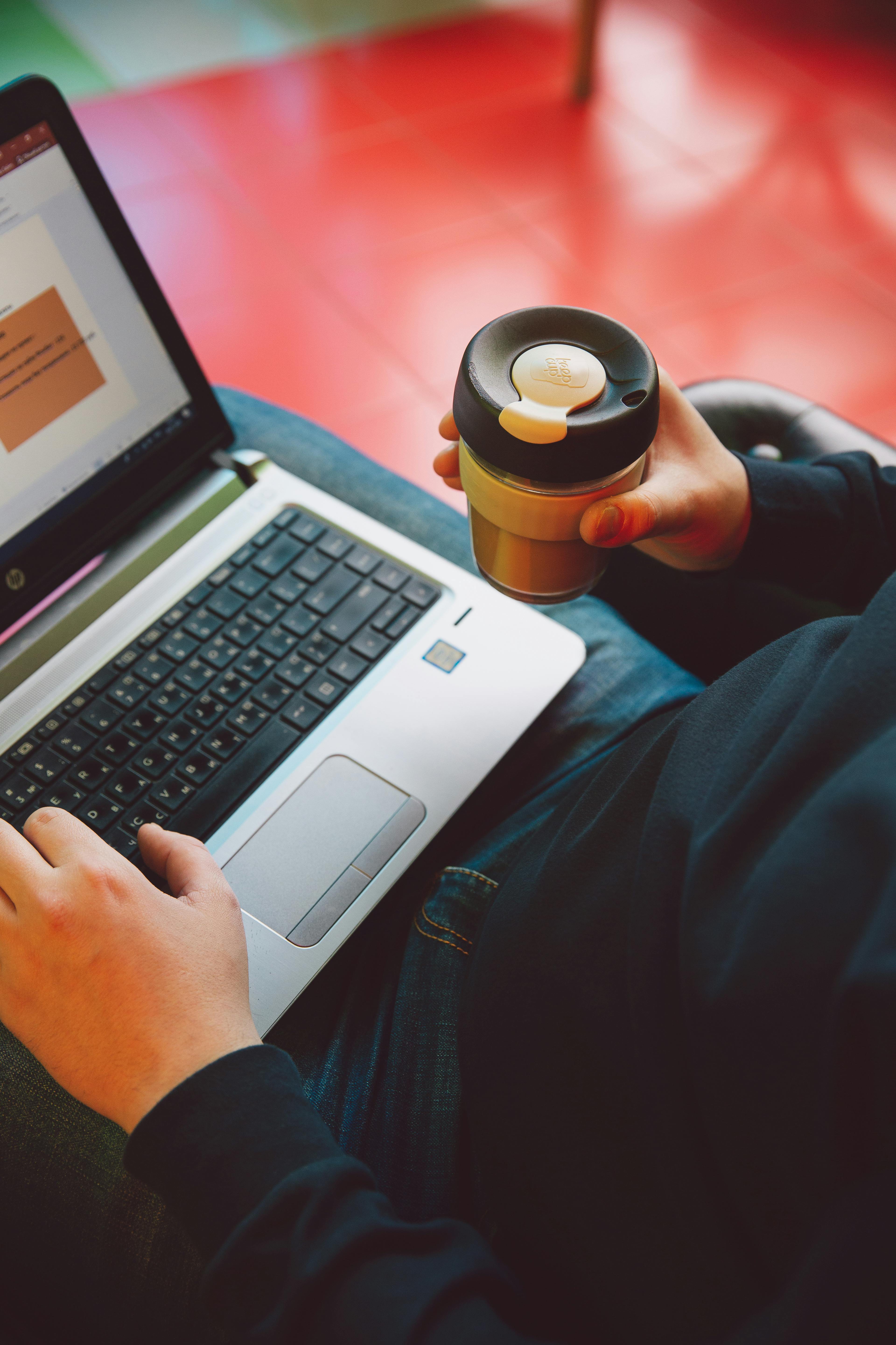 person in black long sleeve shirt holding black and silver laptop computer