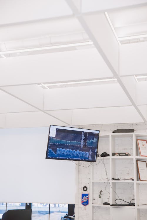 Черный монитор компьютера с плоским экраном включен возле белой стены