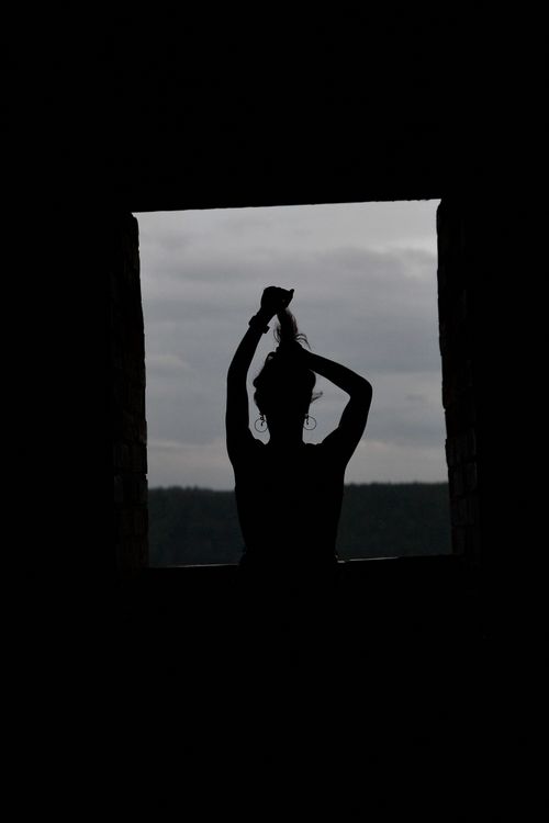 Free Silhouette of a woman with an updo standing in a castle window in Turaida, Latvia. Stock Photo