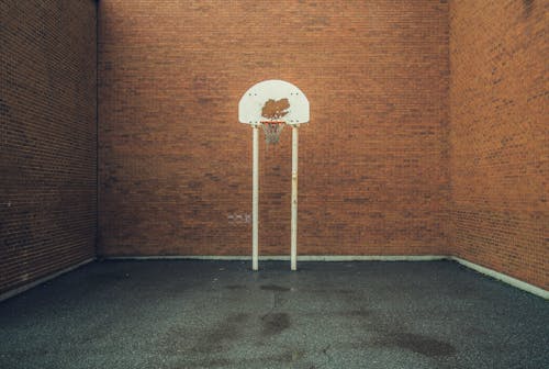 Basketball Ring Near Brown Brick Walls
