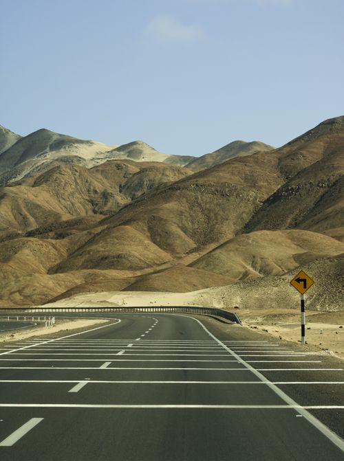 Free A scenic mountain highway curving through arid landscapes under a clear blue sky, ideal for travel concepts. Stock Photo