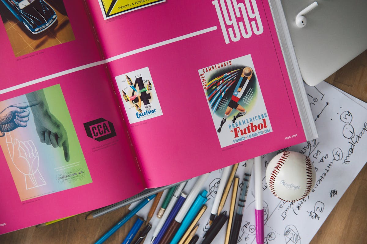 Person using a smartphone while sitting at a desk with stacked books