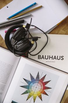 A creative study arrangement featuring a Bauhaus book, headphones, pencils, and a vibrant color wheel.. pexels, creative, stu