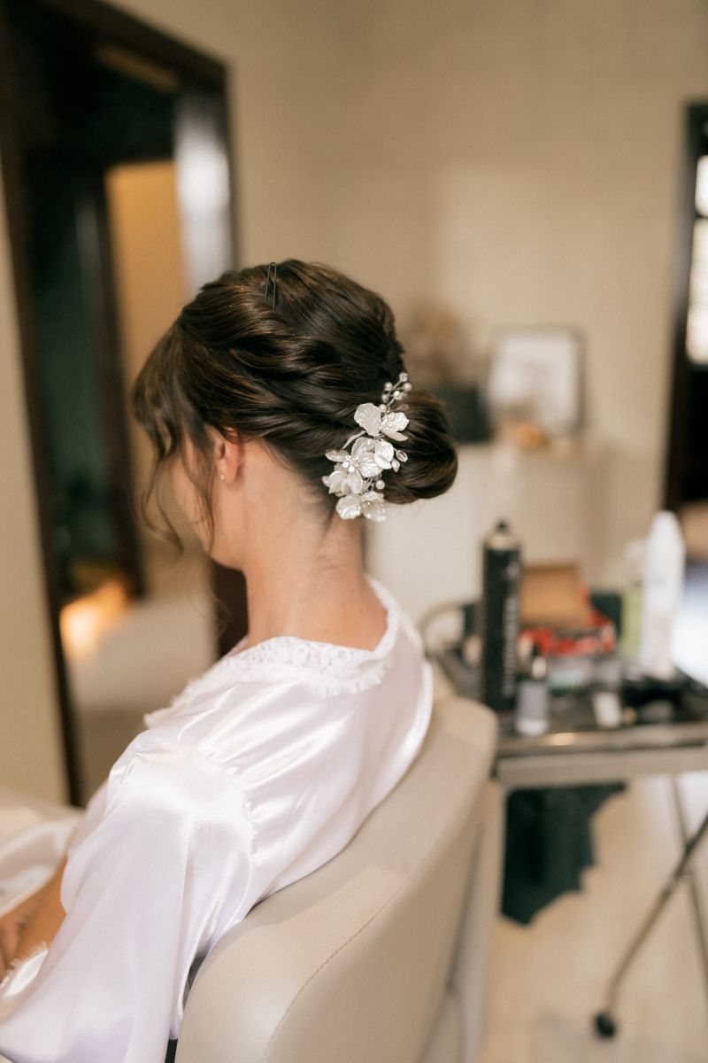 Back view of a bride's pinned chignon dressed with fresh jasmine blooms