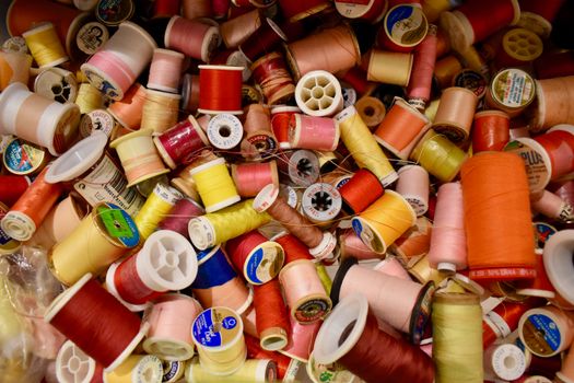 A vibrant collection of multicolored sewing thread spools, showcasing creativity and craft.